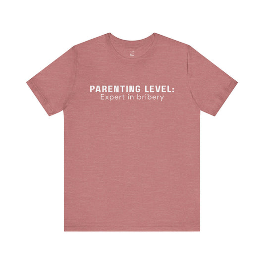Parenting Humor Shirt | Unisex T-Shirt | Funny Parent Tee | Gift for Moms and Dads | Casual Family Outfit | “Parenting Level: Expert in Bribery”