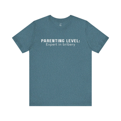 Parenting Humor Shirt | Unisex T-Shirt | Funny Parent Tee | Gift for Moms and Dads | Casual Family Outfit | “Parenting Level: Expert in Bribery”