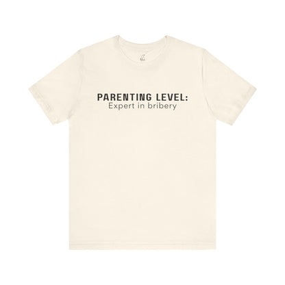 Parenting Humor Shirt | Unisex T-Shirt | Funny Parent Tee | Gift for Moms and Dads | Casual Family Outfit | “Parenting Level: Expert in Bribery”