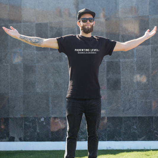 Parenting Humor Shirt | Unisex T-Shirt | Funny Parent Tee | Gift for Moms and Dads | Casual Family Outfit | “Parenting Level: Expert in Bribery”