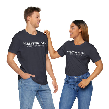 Parenting Humor Shirt | Unisex T-Shirt | Funny Parent Tee | Gift for Moms and Dads | Casual Family Outfit | “Parenting Level: Expert in Bribery”