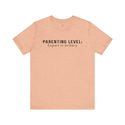 Parenting Humor Shirt | Unisex T-Shirt | Funny Parent Tee | Gift for Moms and Dads | Casual Family Outfit | “Parenting Level: Expert in Bribery”