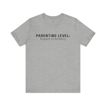 Parenting Humor Shirt | Unisex T-Shirt | Funny Parent Tee | Gift for Moms and Dads | Casual Family Outfit | “Parenting Level: Expert in Bribery”