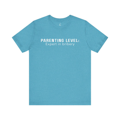 Parenting Humor Shirt | Unisex T-Shirt | Funny Parent Tee | Gift for Moms and Dads | Casual Family Outfit | “Parenting Level: Expert in Bribery”