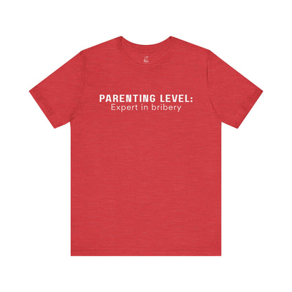 Parenting Humor Shirt | Unisex T-Shirt | Funny Parent Tee | Gift for Moms and Dads | Casual Family Outfit | “Parenting Level: Expert in Bribery”