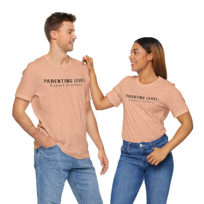 Parenting Humor Shirt | Unisex T-Shirt | Funny Parent Tee | Gift for Moms and Dads | Casual Family Outfit | “Parenting Level: Expert in Bribery”